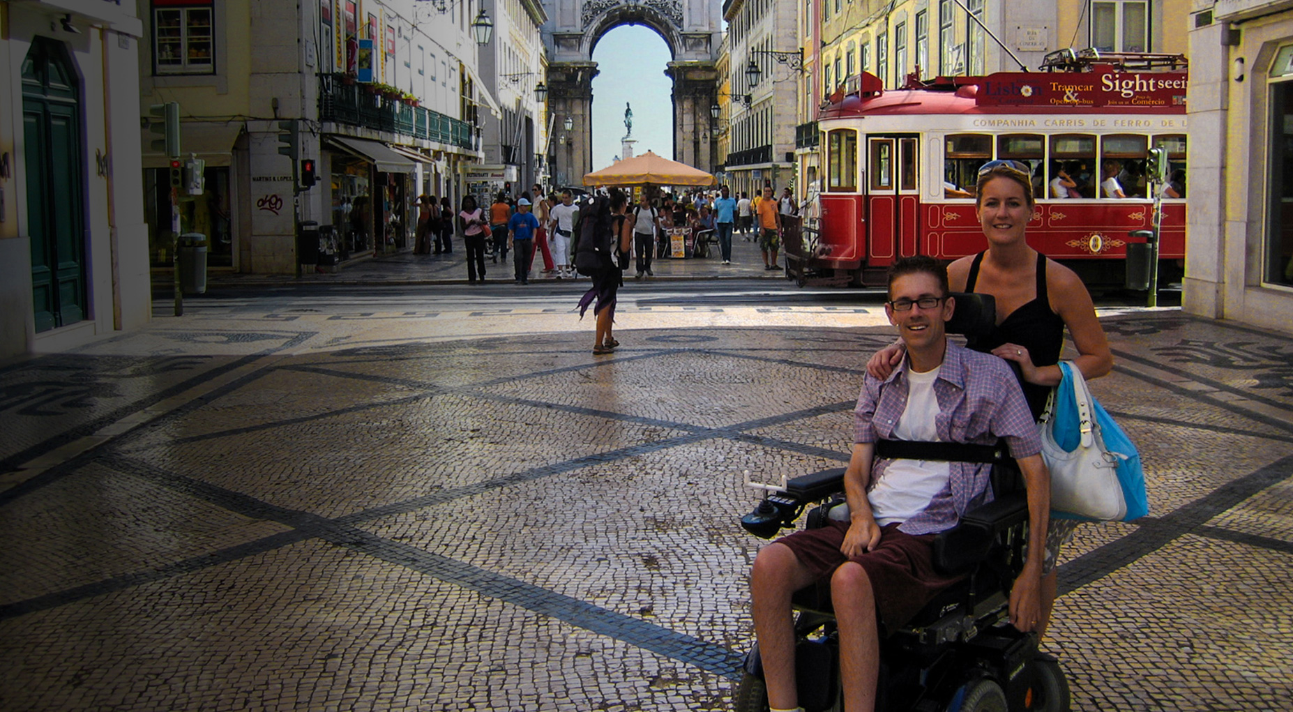 Vista da Rua Augusta na Baixa de Lisboa com duas pessoas, uma das quais em cadeira de rodas